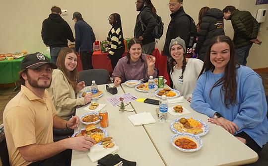 people at a table eating and smiling